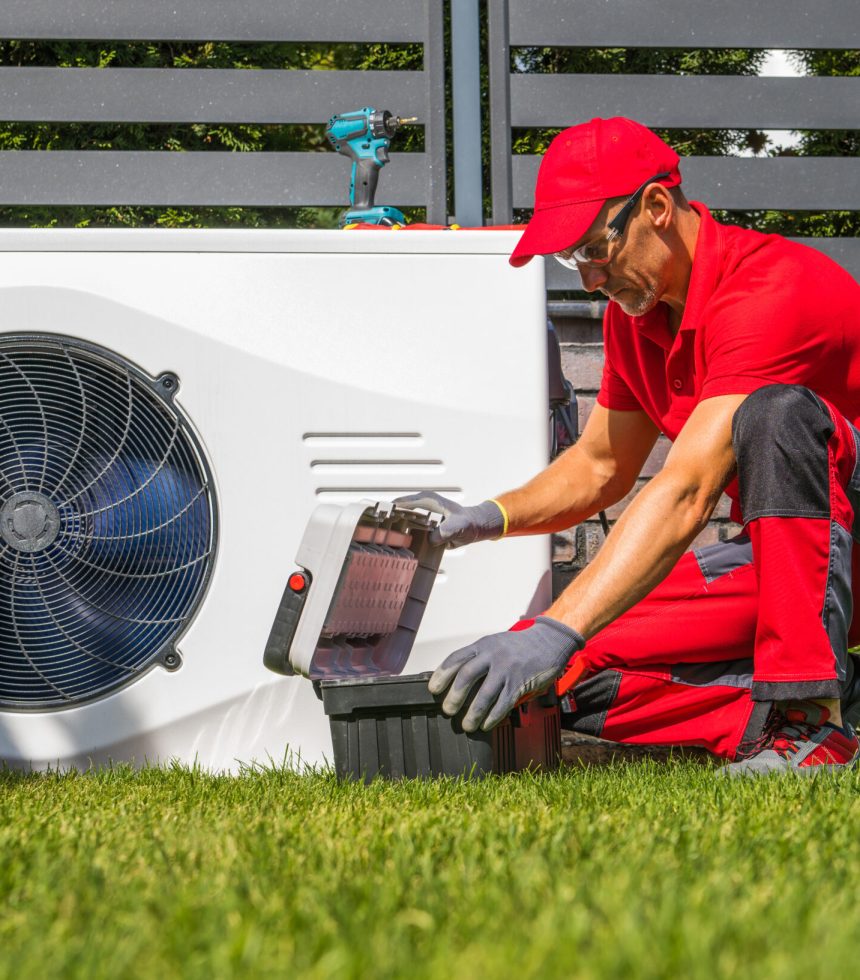 Professional Caucasian Heat Pumps Technician in His 40s Installing New Residential Modern Heating Device. HVAC Industry Theme.